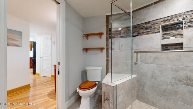a bathroom with a toilet and a shower