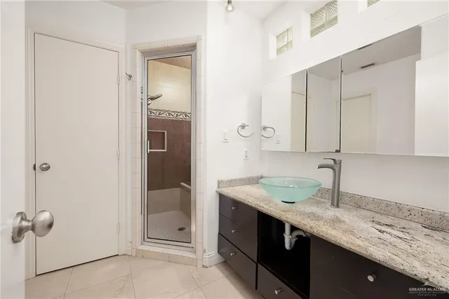 a bathroom with a granite countertop sink and a mirror