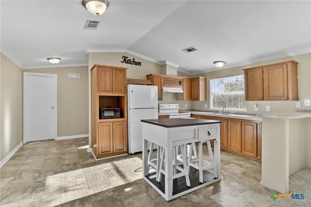 a kitchen with granite countertop a sink cabinets and stainless steel appliances