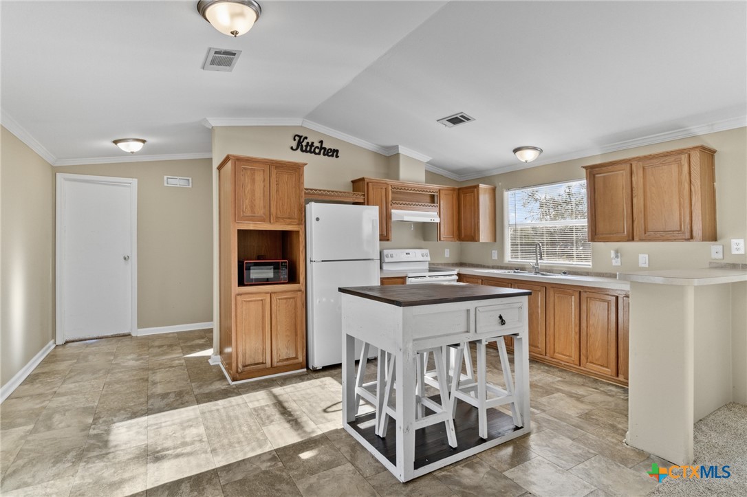 705 Peabody Street Edna, TX 77957 - Photo 8 of 24 a kitchen with granite countertop a sink cabinets and stainless steel appliances