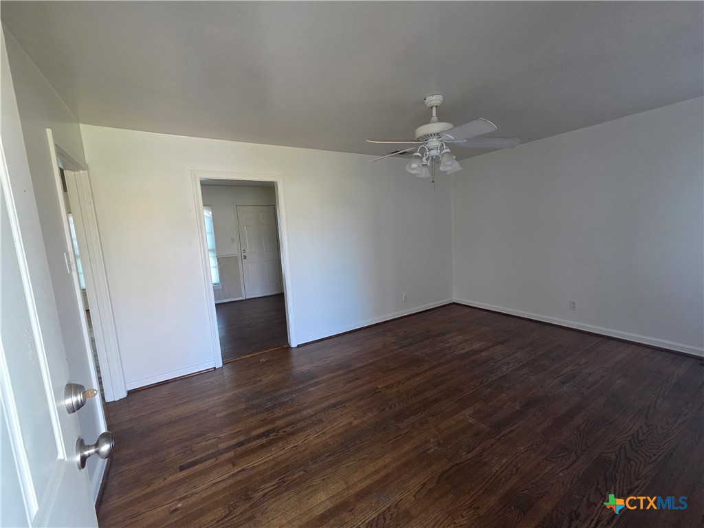 1506 South 9th Street Temple, TX 76504 - Photo 2 of 17 an empty room with wooden floor and ceiling fan