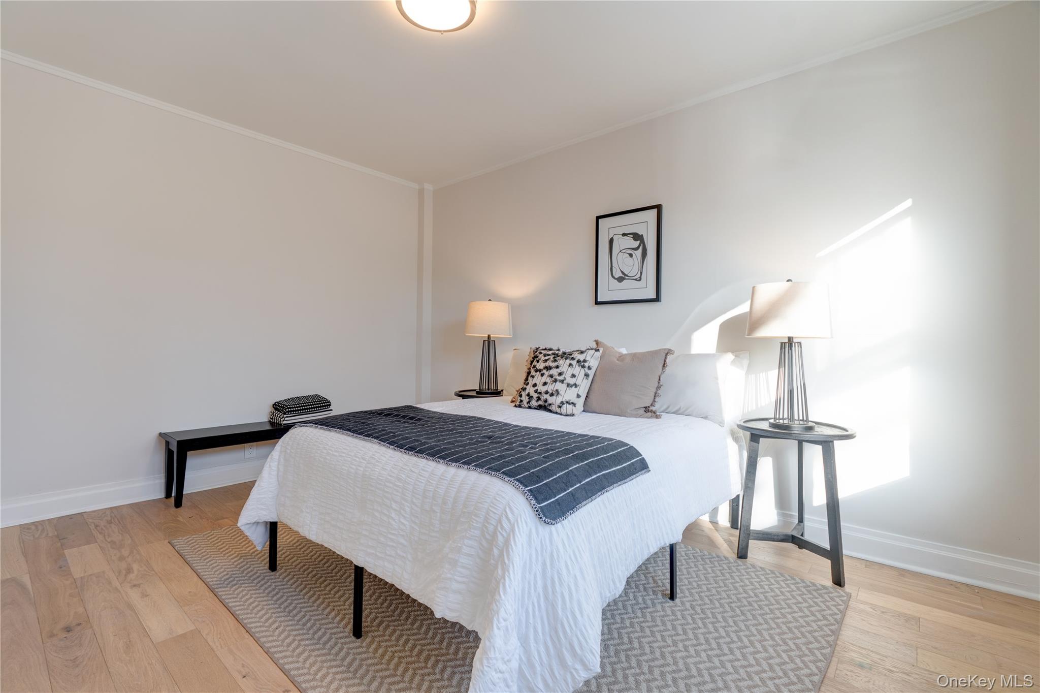 2226 76th Street, Unit C3 Queens, NY 11370 - Photo 17 of 20 a bedroom with a bed and a lamp