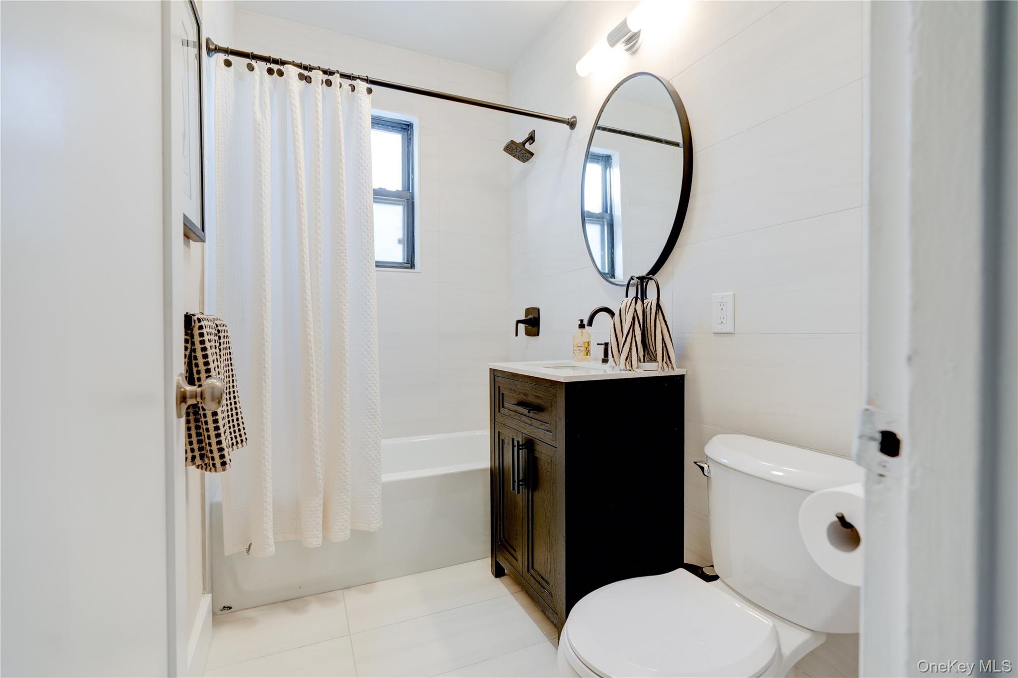 2226 76th Street, Unit C3 Queens, NY 11370 - Photo 19 of 20 a bathroom with a toilet a sink and a mirror