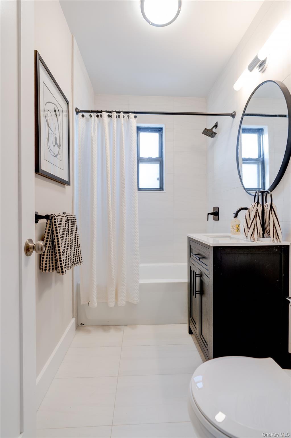 2226 76th Street, Unit C3 Queens, NY 11370 - Photo 20 of 20 a bathroom with a sink a toilet and a mirror