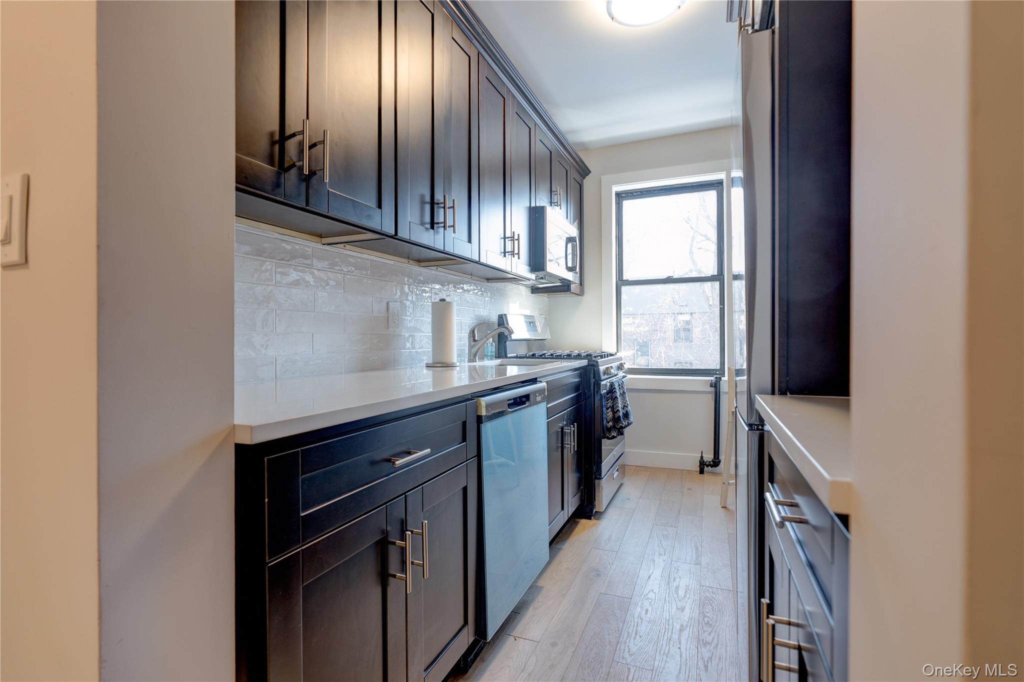 2226 76th Street, Unit C3 Queens, NY 11370 - Photo 5 of 20 a kitchen with stainless steel appliances granite countertop a stove a sink and a refrigerator