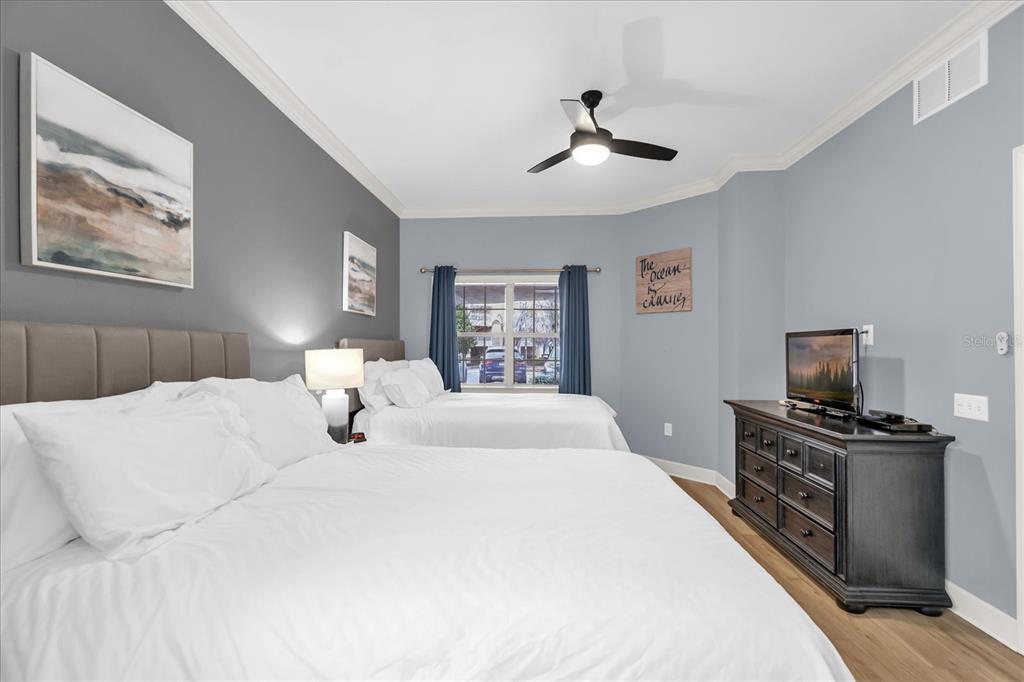 1362 Centre Ct Ridge Drive, Unit 102 Reunion, FL 34747 - Photo 20 of 35 a bedroom with a bed and a flat screen tv