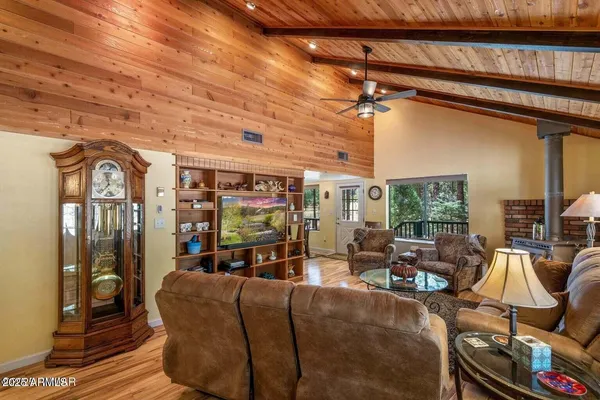 a living room with furniture a flat screen tv and floor to ceiling window