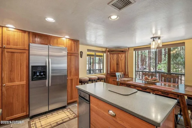 a kitchen with stainless steel appliances granite countertop a sink and a refrigerator