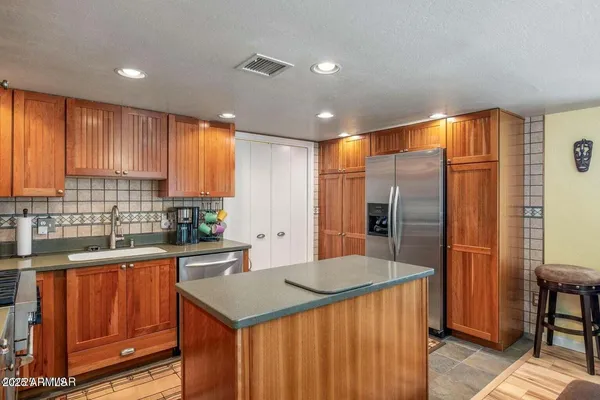 a kitchen with stainless steel appliances granite countertop a sink a stove and a refrigerator