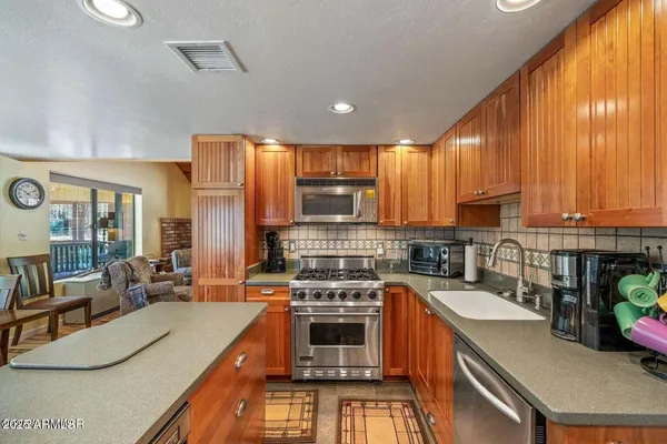 a kitchen with a stove a sink a microwave a dining table and chairs