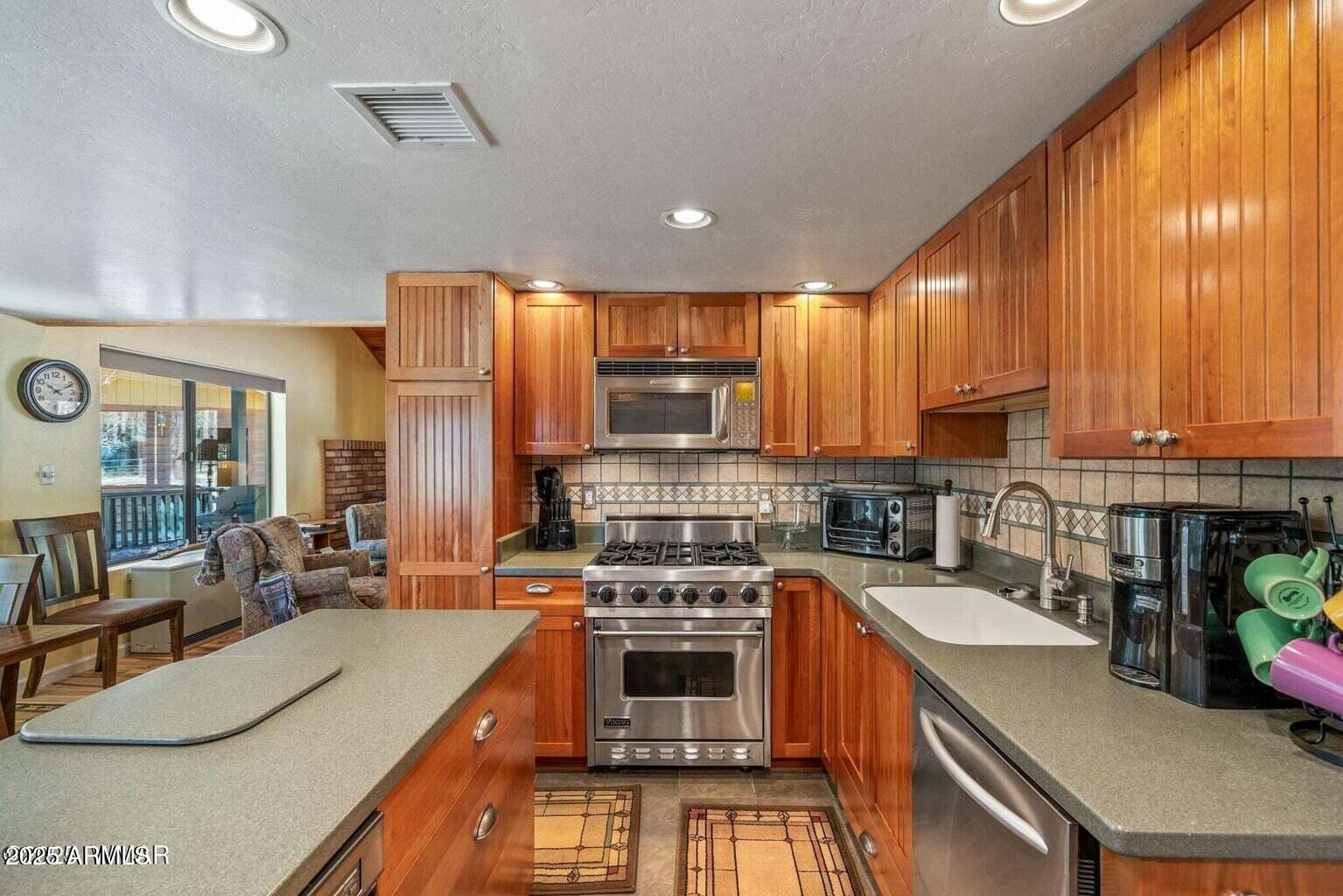 61 County Road 2266 Alpine, AZ 85920 - Photo 4 of 51 a kitchen with a stove a sink a microwave a dining table and chairs