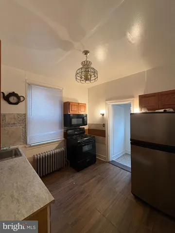 a kitchen with granite countertop a refrigerator and a stove top oven