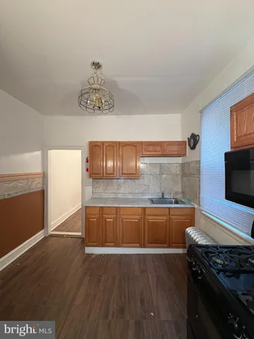 a kitchen with granite countertop a stove and a wooden floor