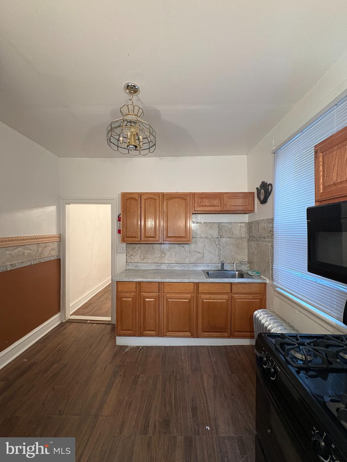 3219 North 29th Street Philadelphia, PA 19129 - Photo 7 of 16 a kitchen with granite countertop a stove and a wooden floor