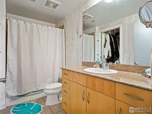 a bathroom with a granite countertop sink a toilet and a mirror