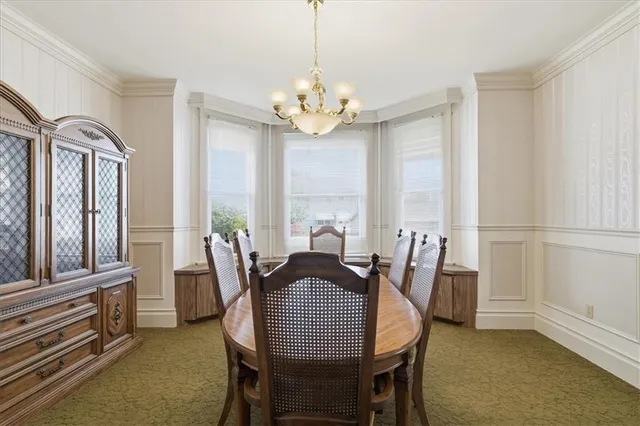 a view of a dining room with furniture a chandelier and wooden floor