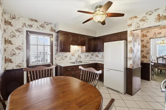 a kitchen with stainless steel appliances granite countertop a refrigerator a stove a sink dishwasher a dining table and chairs with wooden floor