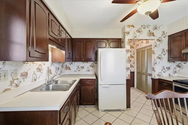 a kitchen with stainless steel appliances granite countertop a refrigerator a oven a sink dishwasher and white cabinets with wooden floor