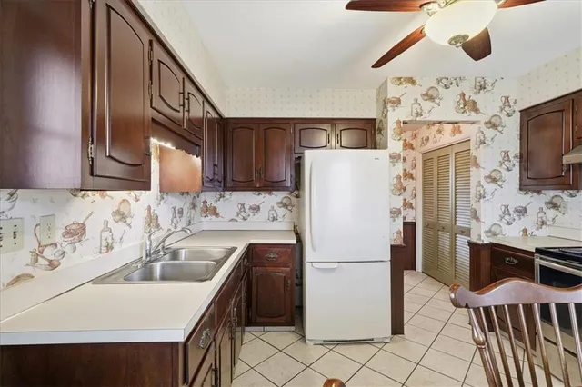 a kitchen with stainless steel appliances granite countertop a refrigerator a oven a sink dishwasher and white cabinets with wooden floor