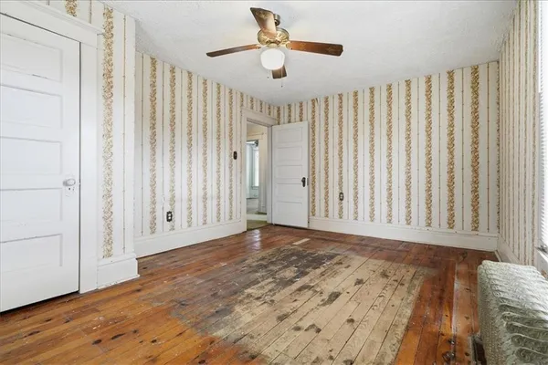 a view of a livingroom with wooden floor and a ceiling fan