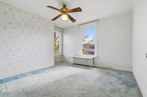 en empty room with windows and ceiling fan