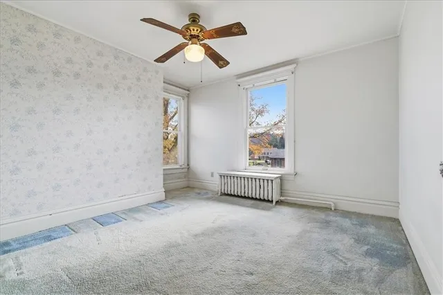 en empty room with windows and ceiling fan