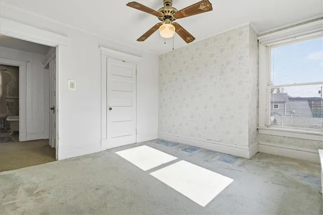 an empty room with closet and windows