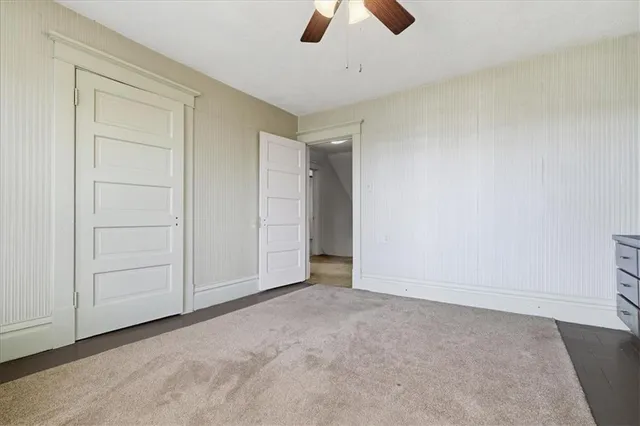 an empty room with chandelier fan