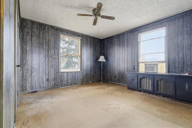 an empty room with windows and cabinet