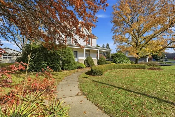 a view of a house with backyard and tree