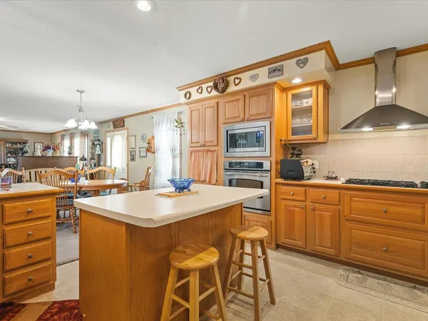 a very nice looking dining room with kitchen island granite countertop a table and chairs