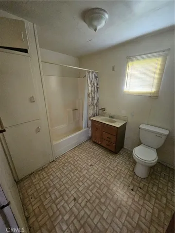 a bathroom with a sink a toilet a window and shower