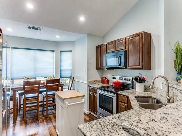 a kitchen that has a stove and a chair in it