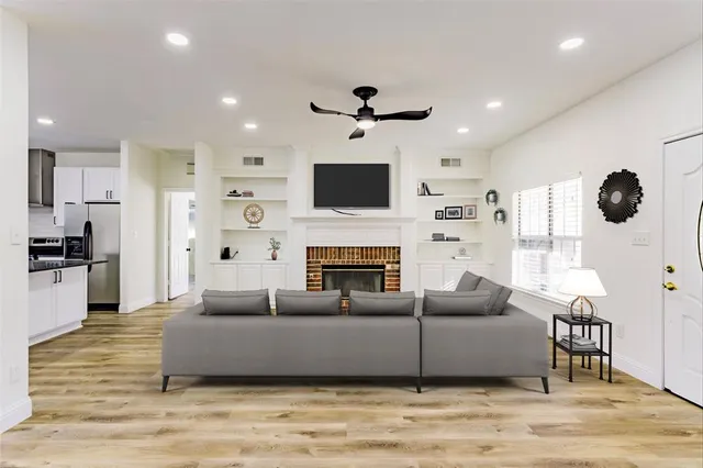 a living room with furniture a fireplace and a flat screen tv