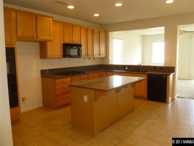 11260 Parma Way Reno, NV 89521 - Photo 2 of 13 a kitchen with stainless steel appliances granite countertop a sink and a refrigerator