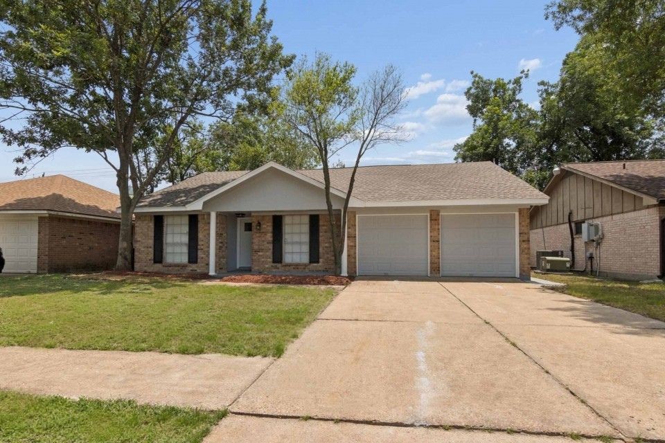 7403 Strawbridge Lane Houston, TX 77040 - Photo 1 of 22 a front view of a house with a garden and trees