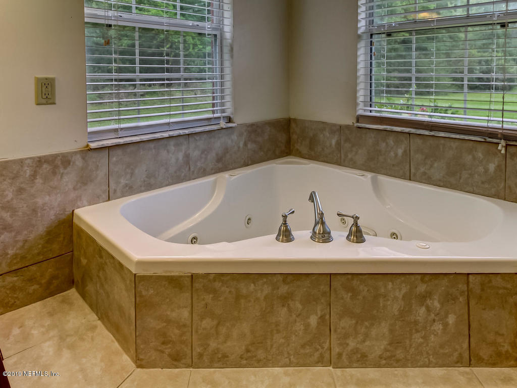 86051 Ellis Estates Landing Road Yulee, FL 32097 - Photo 17 of 35 a bath tub sitting in a bathroom next to a window