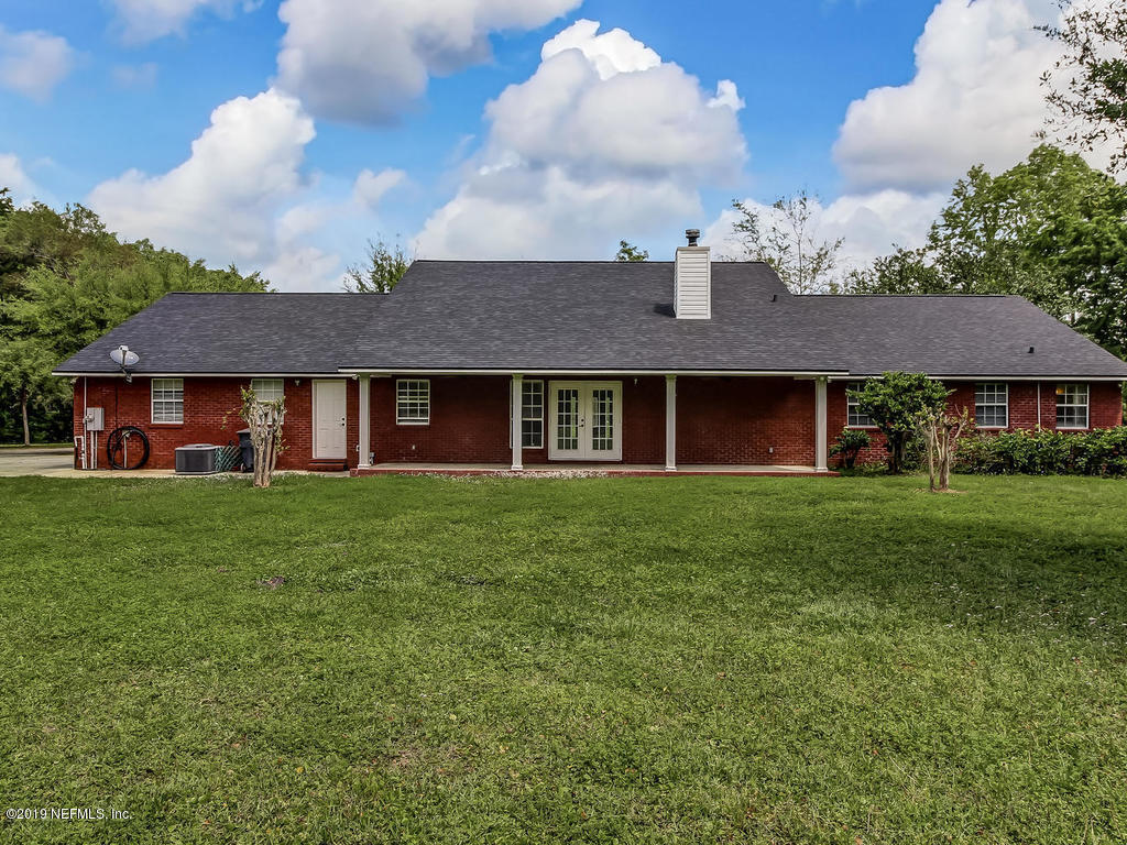 86051 Ellis Estates Landing Road Yulee, FL 32097 - Photo 23 of 35 a view of a brick house with a yard