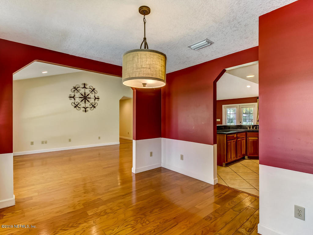 86051 Ellis Estates Landing Road Yulee, FL 32097 - Photo 10 of 35 a view of an empty room with chandelier and wooden floor