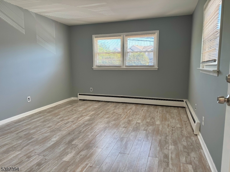 687 Midland Avenue, Unit 2 Garfield, NJ 07026 - Photo 3 of 11 a view of an empty room with wooden floor and a window