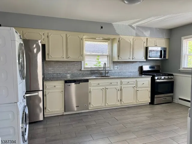 a kitchen with stainless steel appliances granite countertop a refrigerator sink and stove