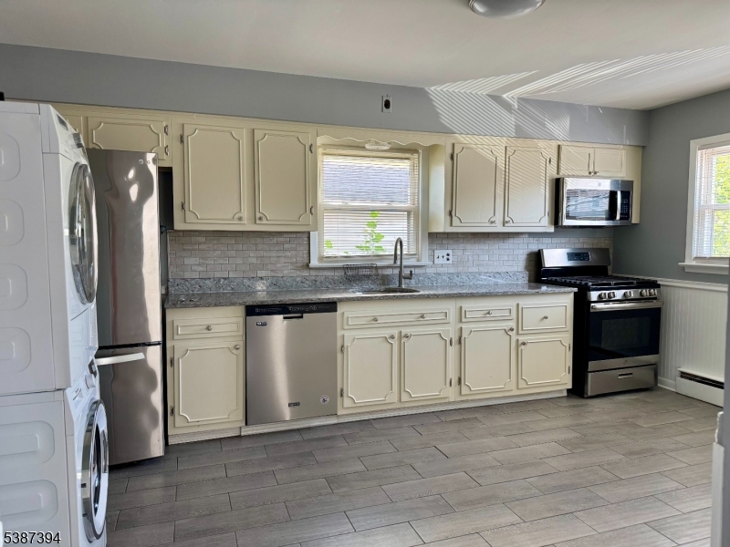 687 Midland Avenue, Unit 2 Garfield, NJ 07026 - Photo 4 of 11 a kitchen with stainless steel appliances granite countertop a refrigerator sink and stove