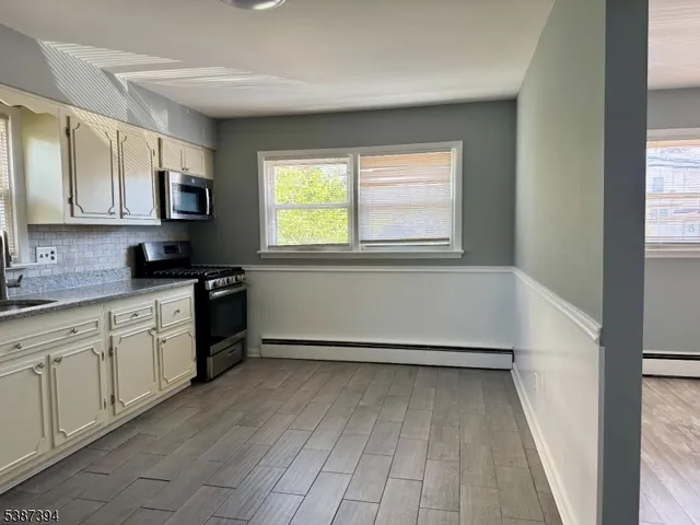 a kitchen with granite countertop a stove a sink and a cabinets