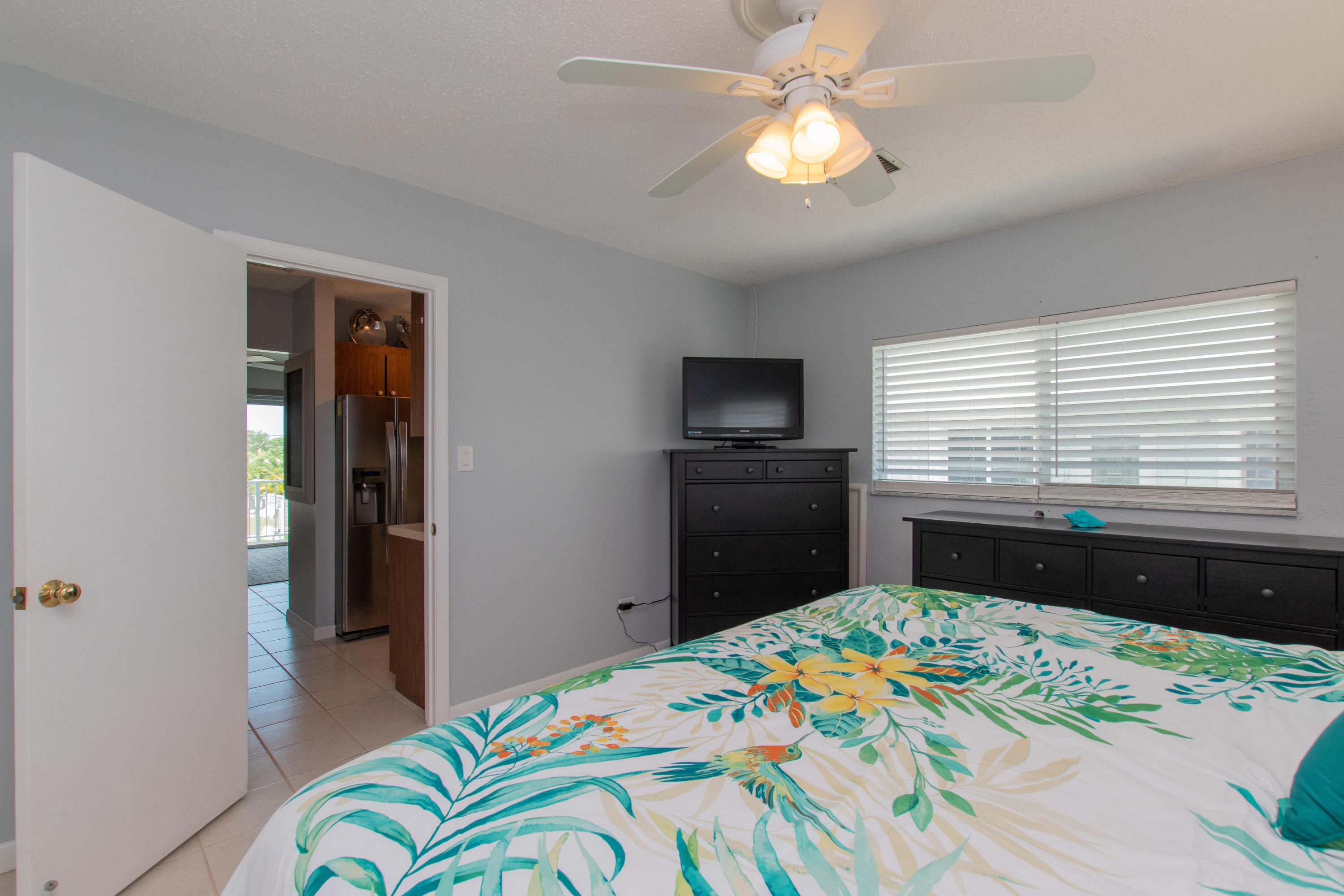 945 98th Street Marathon, FL 33050 - Photo 13 of 49 a bedroom with a bed and a chandelier