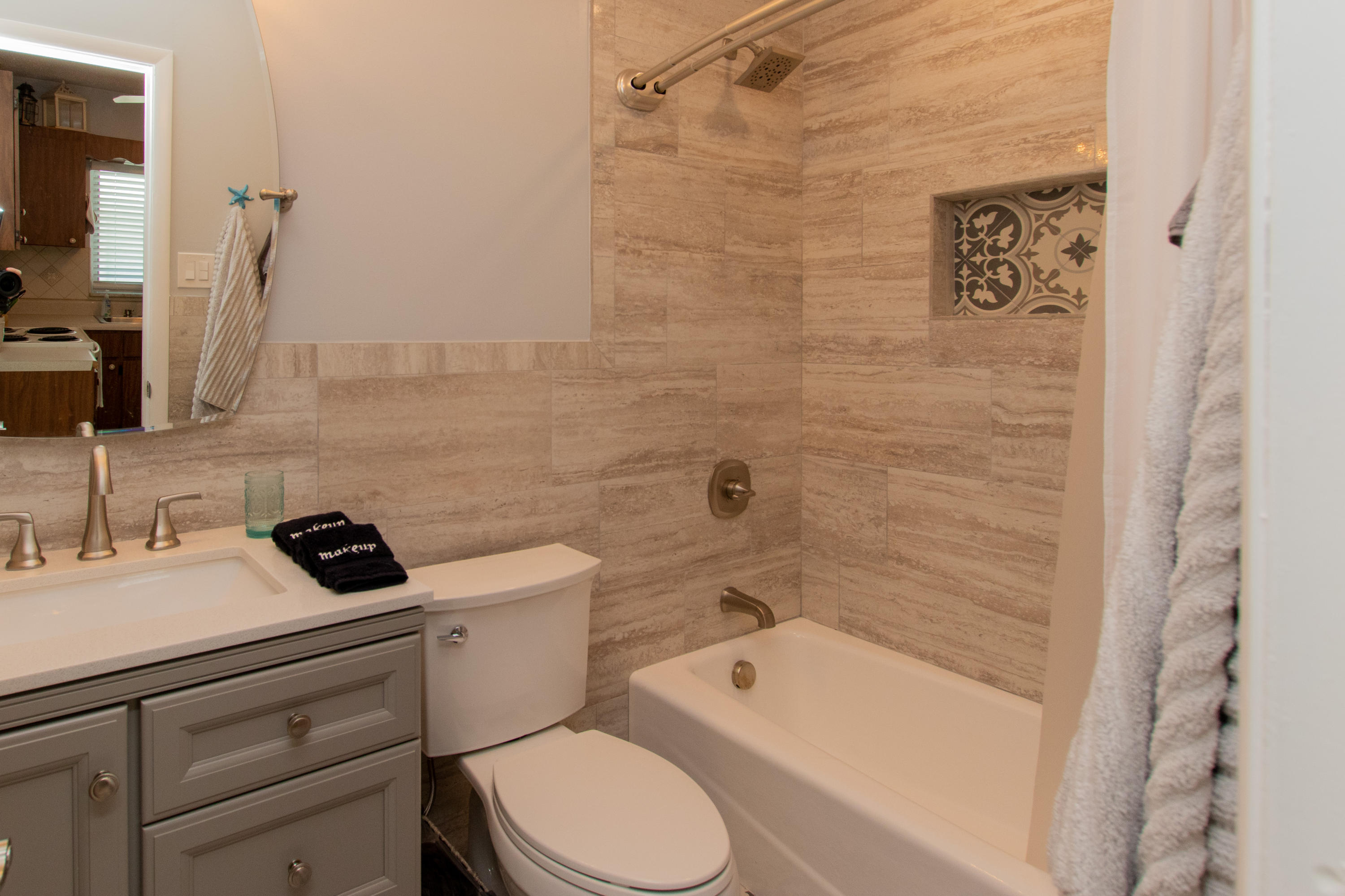 945 98th Street Marathon, FL 33050 - Photo 15 of 49 a bathroom with a toilet sink a mirror a bathtub and shower