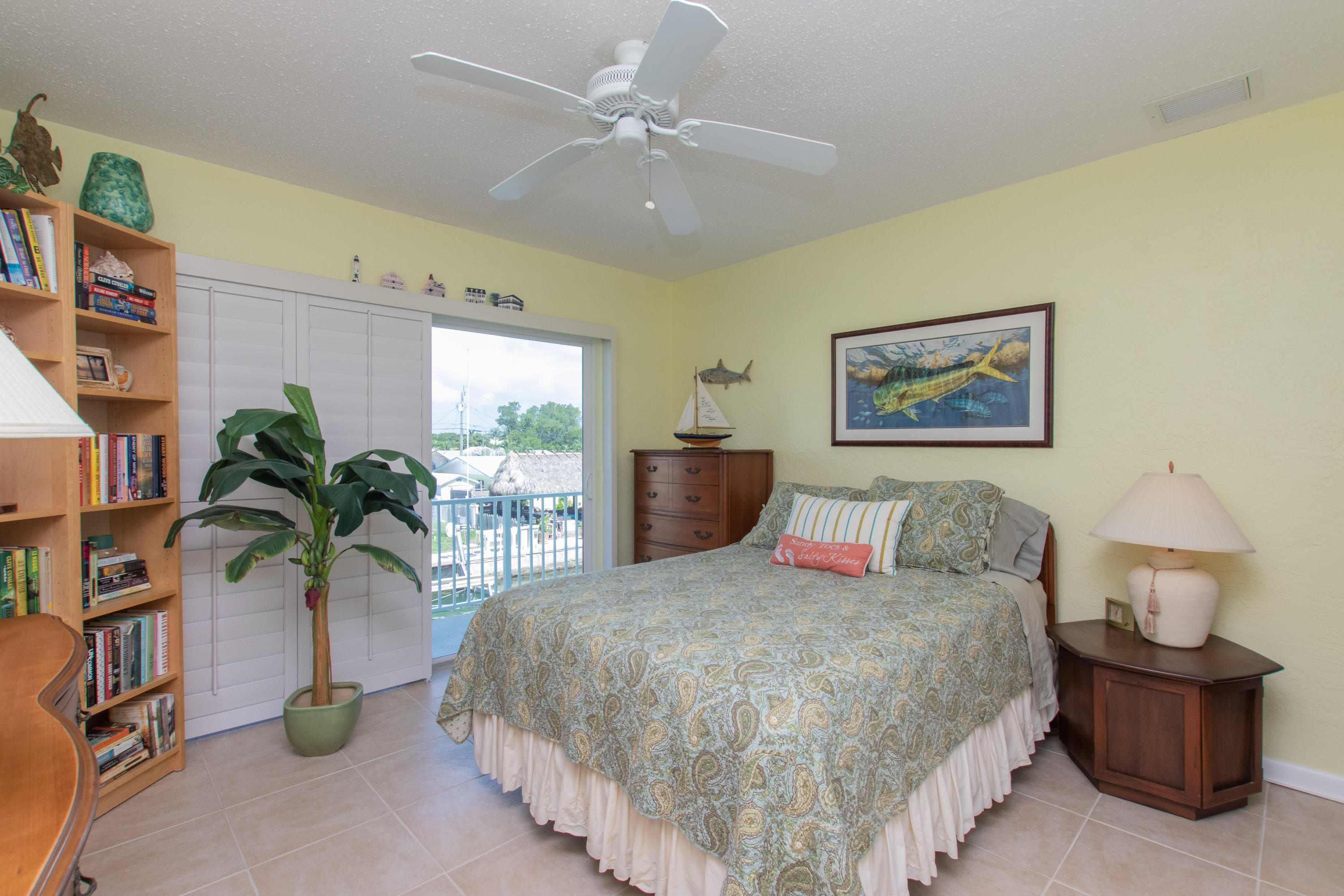 945 98th Street Marathon, FL 33050 - Photo 28 of 49 a bedroom with a large bed and potted plant