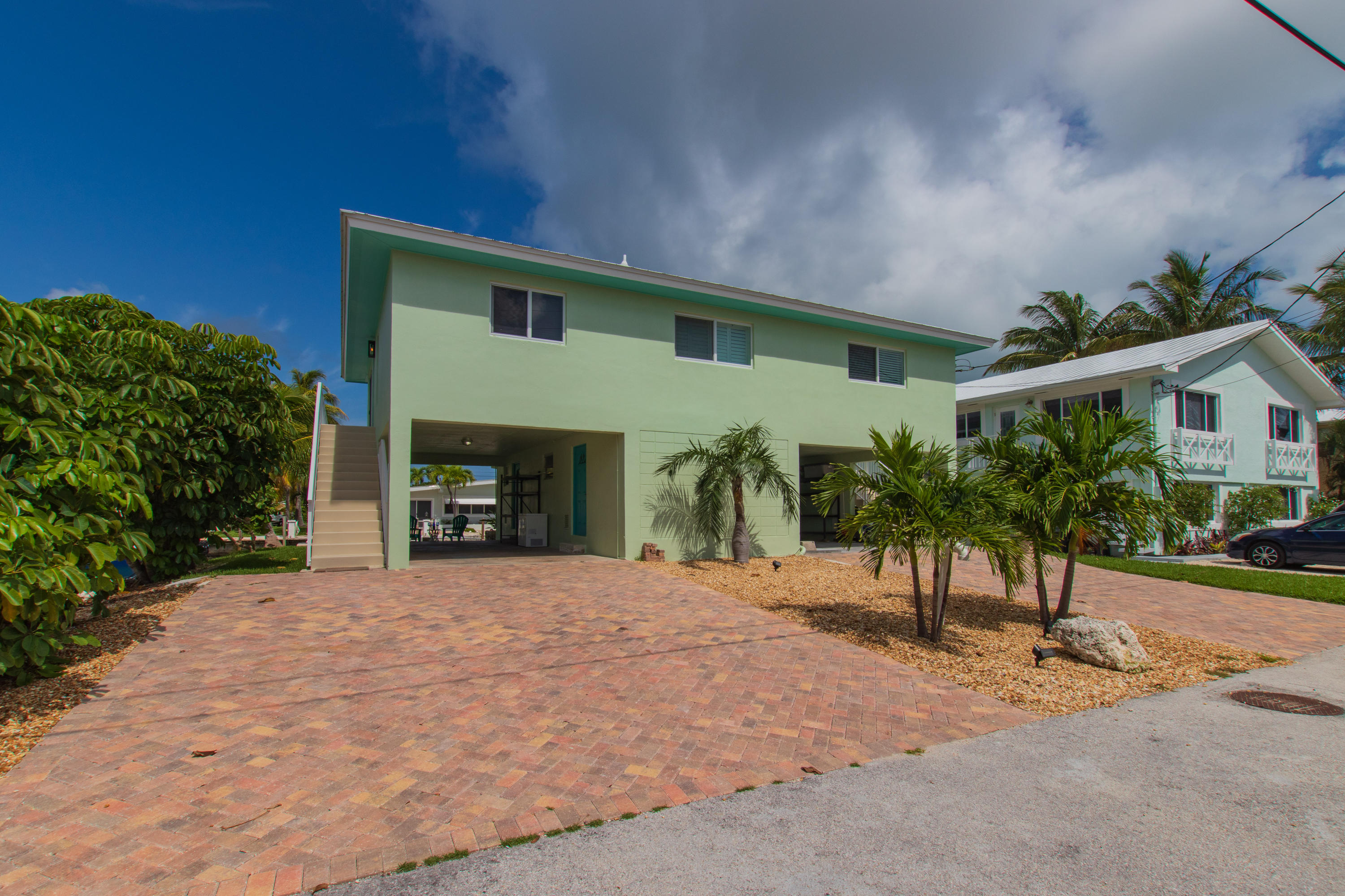 945 98th Street Marathon, FL 33050 - Photo 4 of 49 a front view of a house with a yard and garage