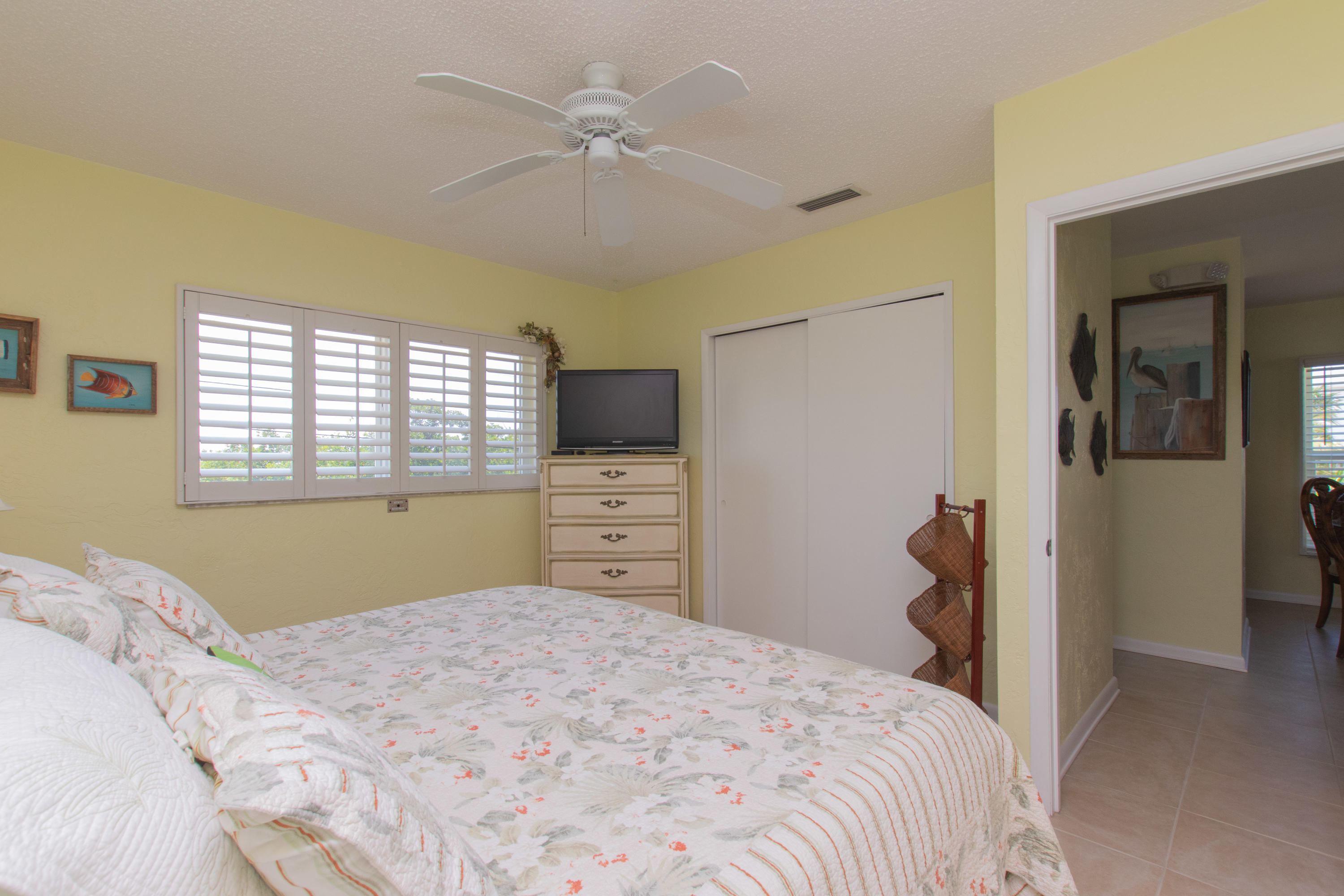 945 98th Street Marathon, FL 33050 - Photo 33 of 49 a bedroom with a bed and a chandelier