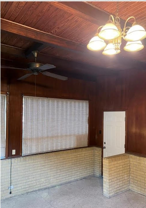 809 North 8th Street Temple, TX 76501 - Photo 16 of 20 A classic chandelier illuminates the room, complemented by a rustic wood-paneled ceiling.