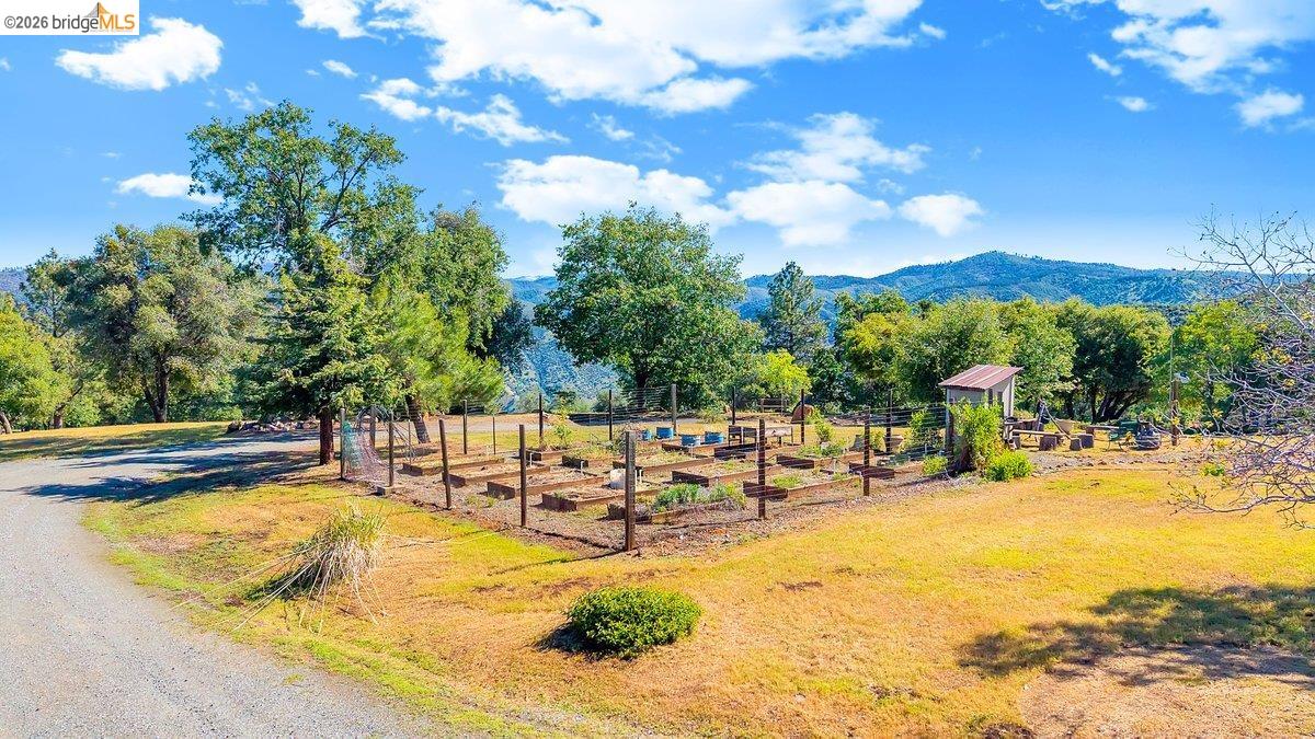 13700 Clements Road Groveland, CA 95321 - Photo 90 of 93 Fenced garden area featuring multiple raised beds and a rustic storage shed